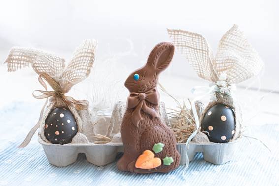 Nesta imagem, temos um coelho de chocolate, ovos de Pascóa, uma decoração simples e linda.