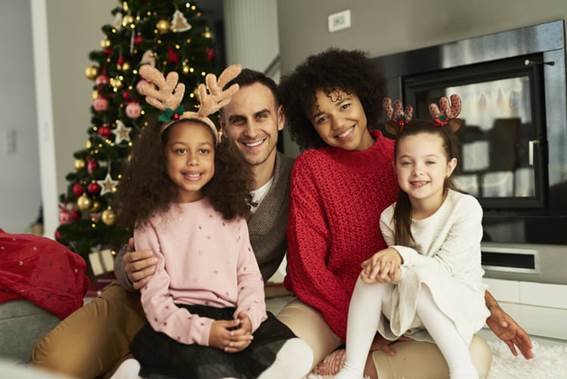 Nesta imagem, esta uma linda família, comemorando uma data maravilhosa que é o Natal, com um sorriso lindo no rosto, arvóre de Natal.