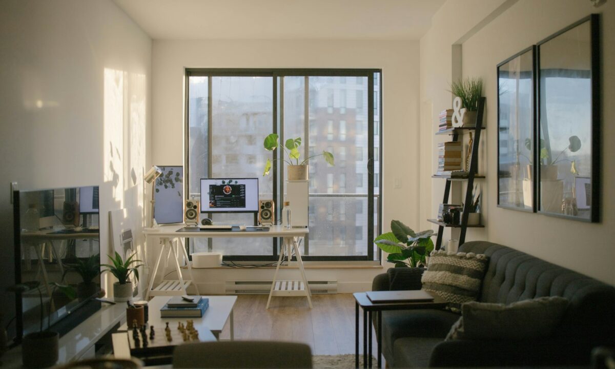 Ambiente pequeno multifuncional combinando home office com escrivaninha e sala de estar