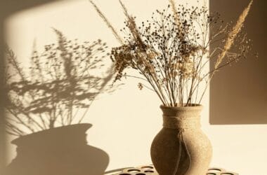 Vaso de cerâmica artesanal marrom sobre toalha de mesa, exemplo de peça artesanal na decoração