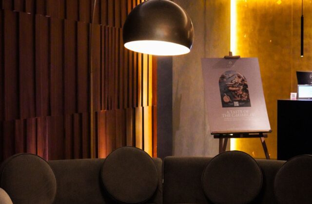 Sala aconchegante com sofá curvo e luminária redonda, exemplo de formas arredondadas na decoração