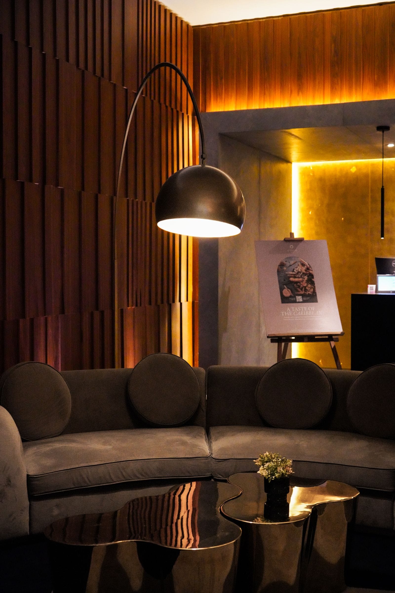 Sala aconchegante com sofá curvo e luminária redonda, exemplo de formas arredondadas na decoração