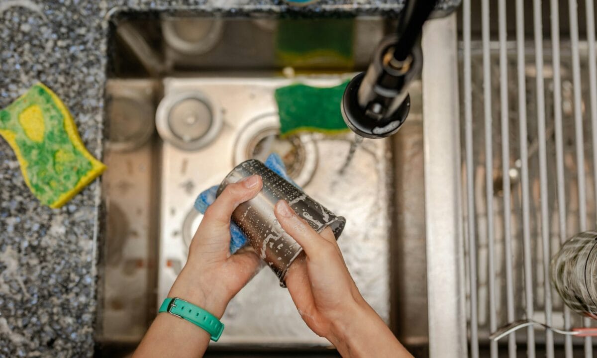 Pessoa limpando a bancada da cozinha com um pano