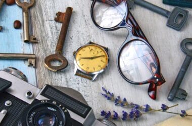 Still life de objetos vintage domésticos: câmera fotográfica antiga, chaves, óculos, relógio de pulso e cartas antigas sobre uma mesa
