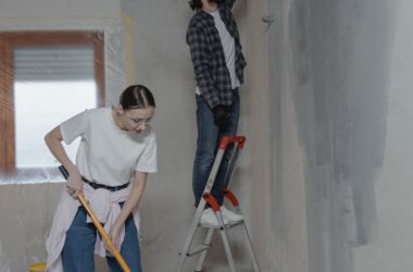 Casal pintando a parede durante uma reforma residencial de baixo custo