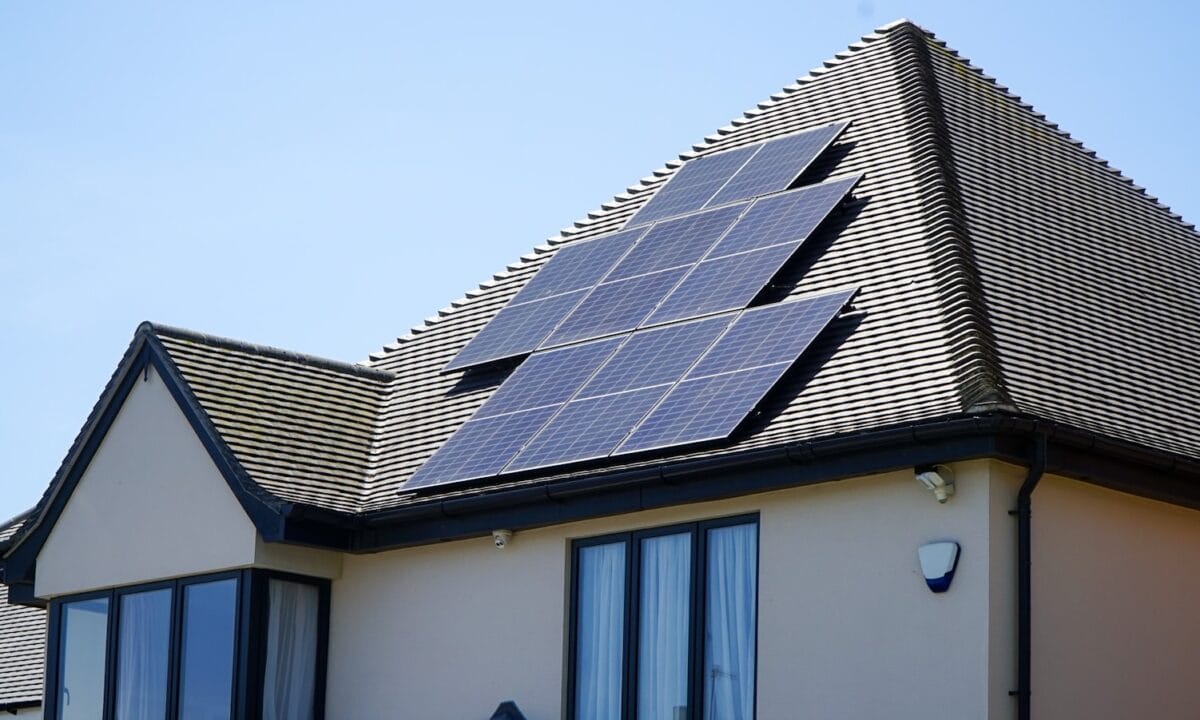 Casa residencial com painéis solares instalados no telhado, símbolo de sustentabilidade
