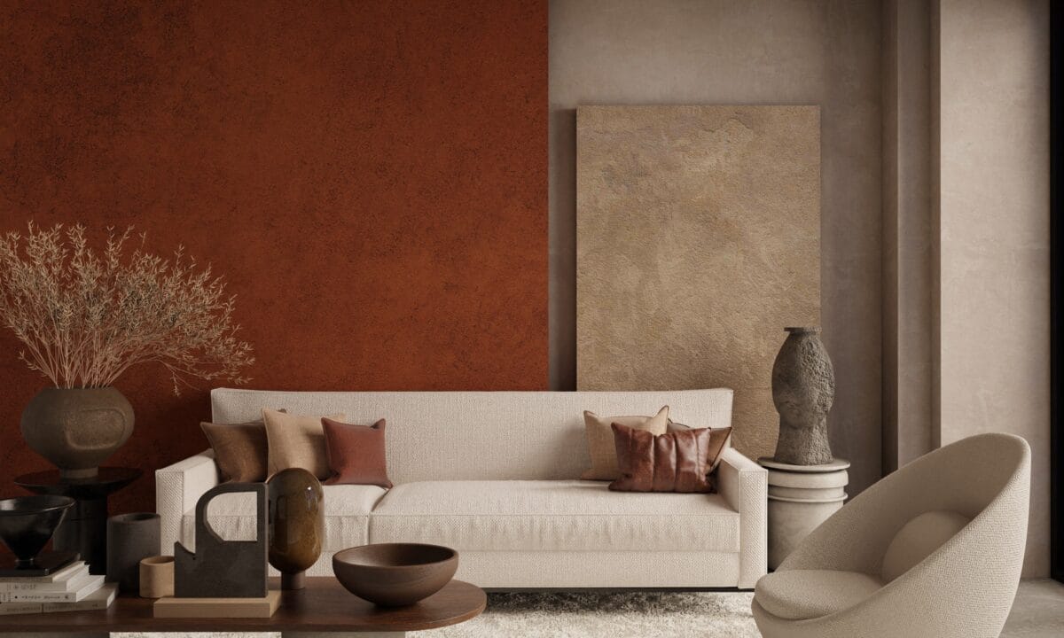Sala de estar minimalista decorada em tons terrosos, com sofá, almofadas e parede em terracota e argila