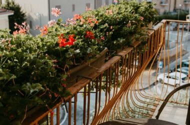 Varanda gourmet pequena decorada com flores, plantas e mesa de bistrô